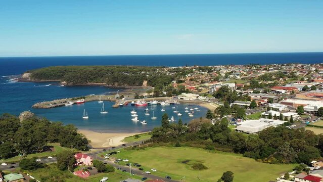 Breakwall protected harbour in Ulladulla coastal town of Australia in aerial 4k.
