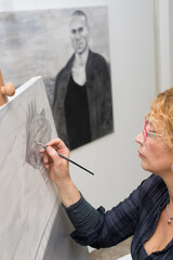 Woman painter painting in her studio