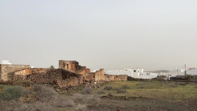 Old ruins of stone building in Lanzarote island with traditional calima haze on the air at sunset
