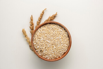 Spelt bran and grains in clay pot isolated on white background