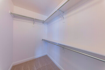 Walk-in closet with wall-mounted shelves with brackets and metal rods