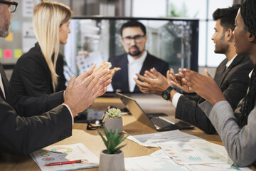 Close up view of clapping hands. Confident middle-aged bearded business man gets congrats and cheers from her applauding multiethnic colleagues after project presentation.