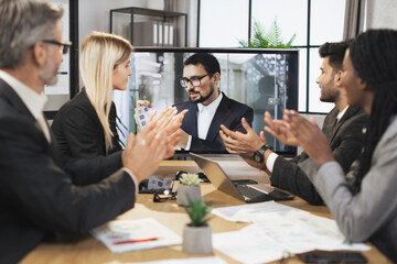 Close up view of clapping hands. Confident middle-aged bearded business man gets congrats and cheers from her applauding multiethnic colleagues after project presentation.