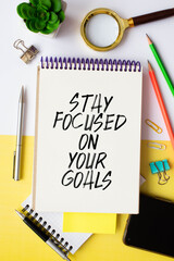 Inspirational quote - Stay focused on your goals. With text message on white paper book
