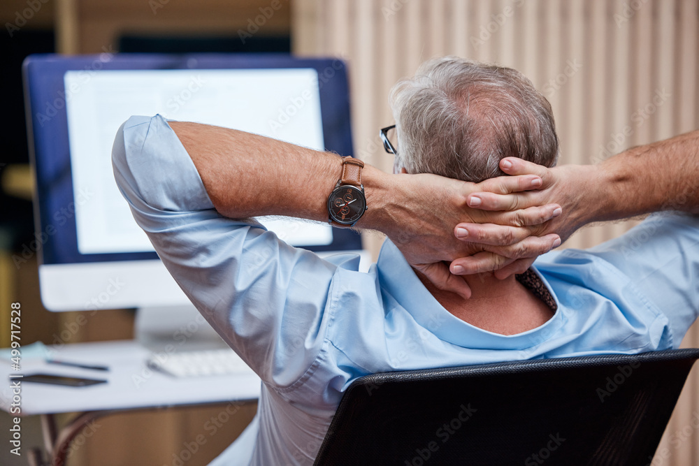 Wall mural Success feels great. Shot of an unrecognizable businessman sitting alone in his office and feeling accomplished while using his computer.