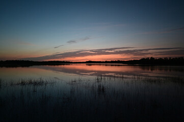 Obraz premium Sunrise cloudscape reflected in calm water of Nine Mile Pond in Everglades National Park, Florida in April.