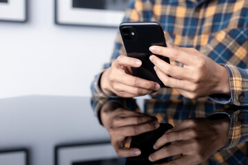using cell phone hand holding mobile texting message contact us.chatting,search internet information in office.technology device communication connecting