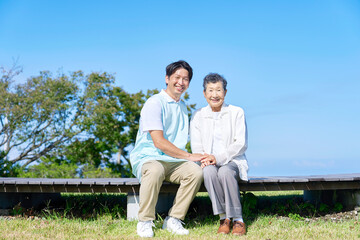 介護士と高齢者　屋外