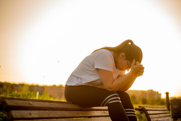 Young latina female sitting at sunset park