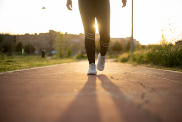 Young female running outside at sunset 