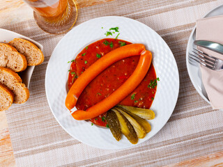 Just cooked pair of Viennese sausages with saft goulash served on plate.