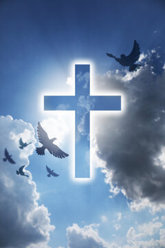 Glowing cross and drawn doves in blue cloudy sky