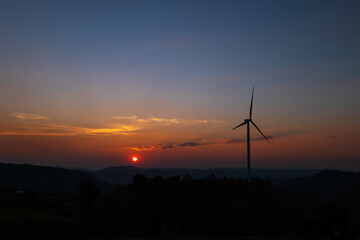 Wind turbine farm on mountain landscape at sunset sky background. Wind power renewable energy concept.
