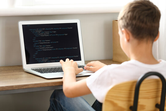 Cute little programmer using modern laptop at home