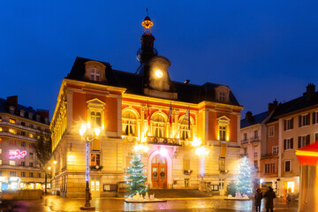 Fototapeta na wymiar Scenic night view of Chambery town hall in central square during winter Christmas season with bright lighting and traditional decorations, France