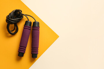 Stylish skipping rope on yellow background