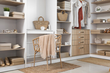 Interior of modern wardrobe with shelves and workplace