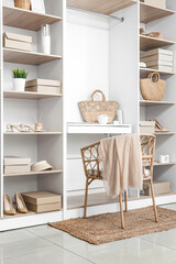 Obraz na płótnie Canvas Interior of modern wardrobe with shelves and workplace