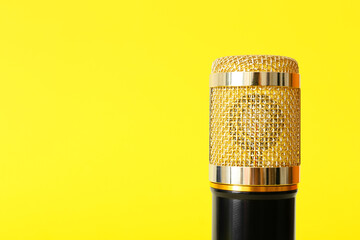 Modern microphone on yellow background, closeup