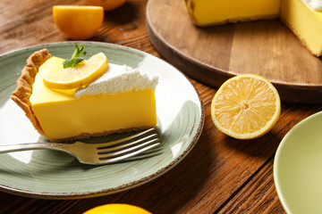 Plate with piece of tasty lemon pie on wooden background