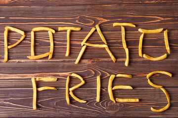 Text POTATO FRIES on wooden background