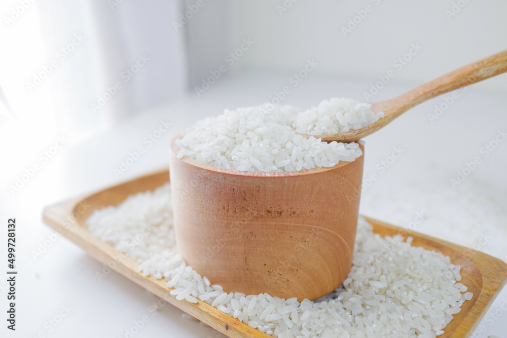 Sticker rice on wooden spoon and wooden bowl