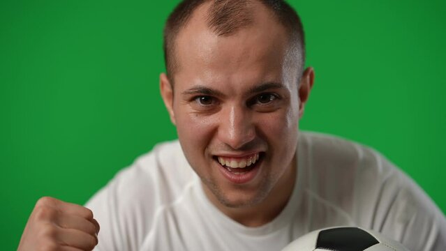 Successful sportsman leaning to camera gesturing yes smiling on green screen. Portrait of satisfied excited Caucasian young man looking at camera posing at chromakey background. Championship