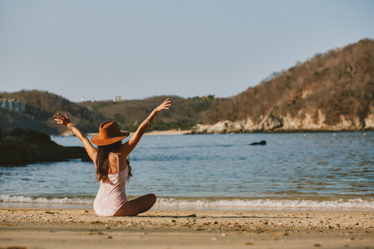 Latin woman sitting on the beach, enjoying the sunset. Woman reading book. Woman on the beach of Huatulco Oaxaca. relaxed young woman. Background cruise. Happy woman on vacation in Mexico. Resting in 