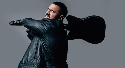 Aggressive guitarist standing with electric guitar Guitarist breaks guitar.