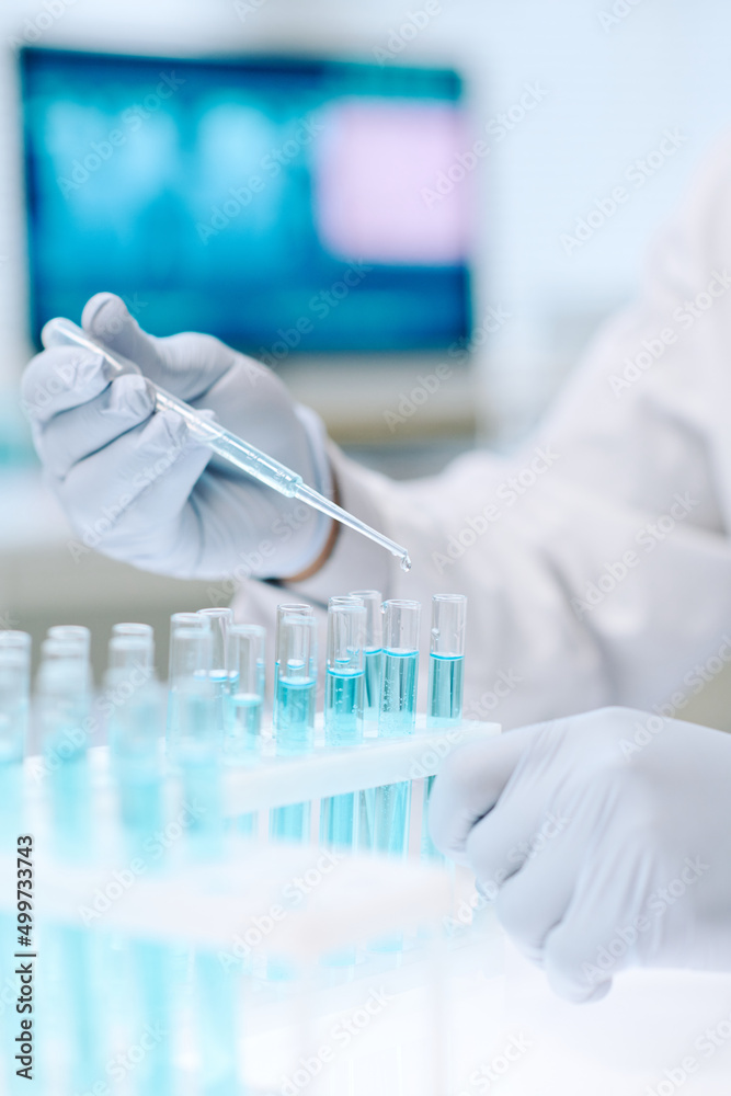 Poster contemporary chemist or researcher in gloves mixing two liquid substances while dropping one of them