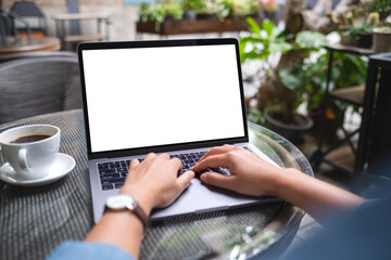 Mockup image of a woman using and working on laptop computer with blank white desktop in the...