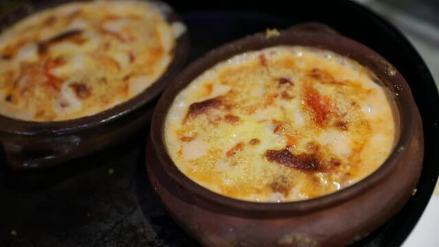 Gourmet seafood. Closeup view of a King Crab hot bubbling cake in a bowl, in the restaurant kitchen.