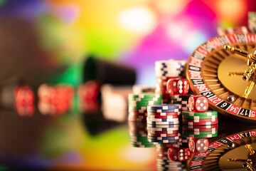 Fototapeta na wymiar Casino theme. Gambling games. Roulette and poker chips on a colorful bokeh background.