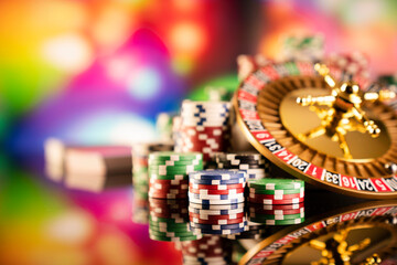 Casino theme.  Gambling games. Roulette and poker chips on a colorful bokeh background.