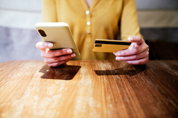 smart phone and credit card hold by the hands of an unrecognizable caucasian woman. Concept of online shopping