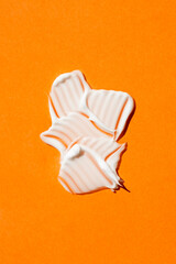 A swatch of cream or face mask. The appearance of the texture of the cream on orange background. Skincare products, natural cosmetic. Beauty concept for face and body care