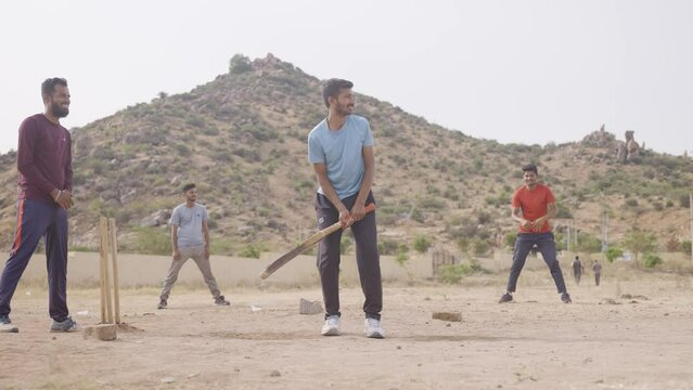 group of college studnets playing cricket at hostel ground during early morning - concept of competition, tournament and active lifestyle.