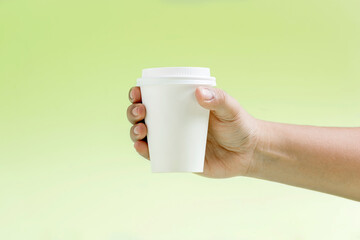 Human hand holding a white plastic cup