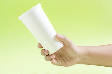 Human hand holding a white plastic cup