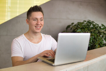 Portrait of a happy young man using laptop.