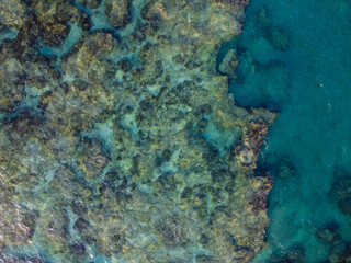 晴れた日の沖縄県島尻郡八重瀬町の透き通る海の干潮時の干潟の空からの写真