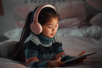 Watching her favourite show. Shot of a little girl using a digital tablet at home.