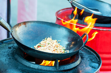 Cooking street food on a hot frying pan.