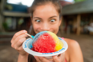 Hawaiian shave ice happy woman tourist making funny face hungry eating sweet frozen snow cone local dessert food of Hawaii - 499742507