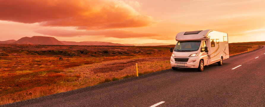 Motorhome camper van RV road trip. People on travel vacation adventure. Tourists in rental car campervan by view of mountains in beautiful nature landscape at sunset