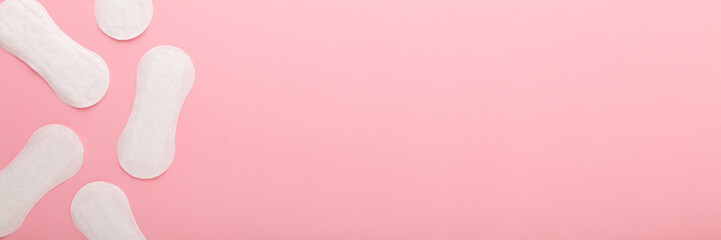 New white panty liners on light pink table background. Pastel color. Closeup. Female daily hygiene....