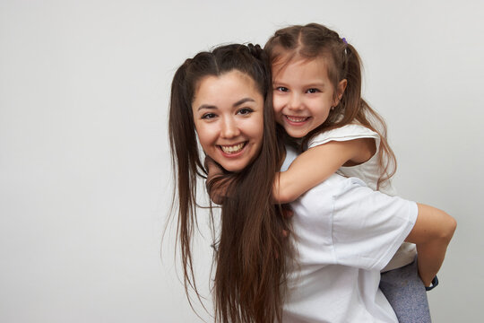 Happy woman and child girl 5-6 years old having fun