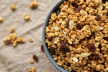 Homemade Granola with raisins and almonds  in a Bowl, top view. Overhead, from above, flat lay. Copy space.