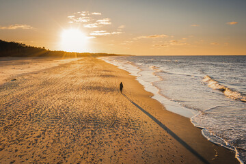 Spacer po plaży w Jastrzębiej Górze nad Bałtykiem, podczas zachodu słońca - obrazy, fototapety, plakaty