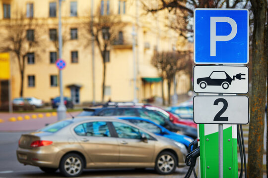 Electric vehicle parking, two spots for electric car only. Parking signs for charge two electric cars on electricity filling station. Road sign at city street, electric vehicle charging station (EV).
